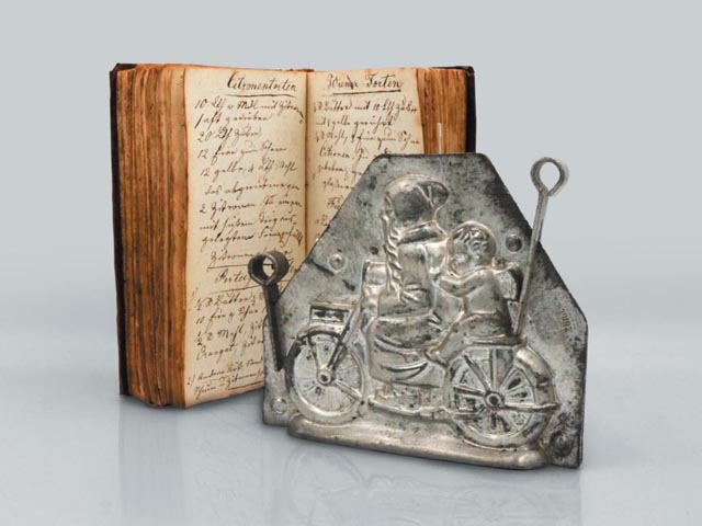 Rezeptbuch des Rheinfelder Zuckerbäckers Franz Peter Sprenger (1810-1890) und Schokoladenform eines Weihnachtsmannes und Putto auf Motorrad aus der Confiserie Berner. Foto: © Fricktaler Museum